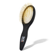 Skip the Groomer vue recto de la brosse montrant la poignée ergonomique et la forme ovale